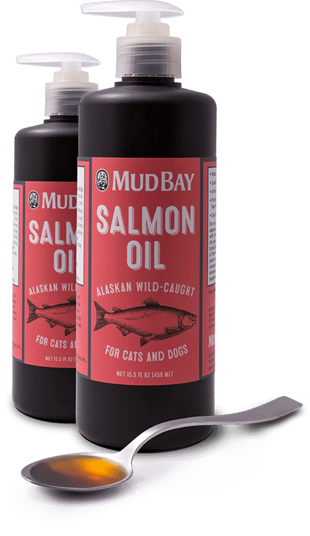 Bottles of Mud Bay brand salmon oil next to a spoonful of the oil.