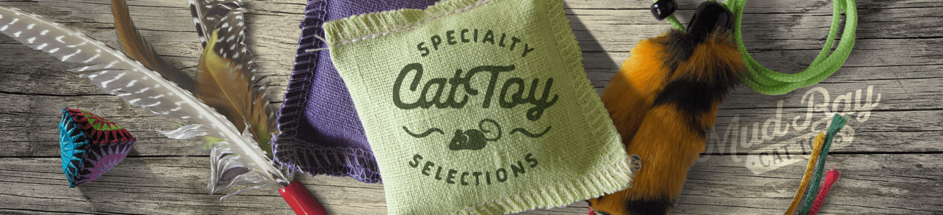 A selection of cat toys set on top of weathered wood